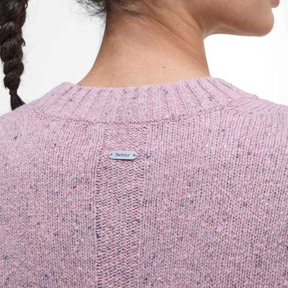 Close-up of a pink knitted sweater with a brand label